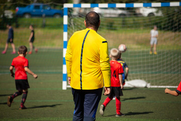 Obraz premium Coach of children's football team. Children's play football. Sports.