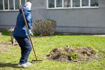 Woman makes flower bed. Gardener is working. Creating beautiful garden. Work in fresh air.