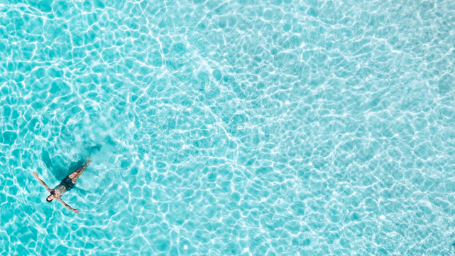 Aerial view of a man swimming at the sea with copy space