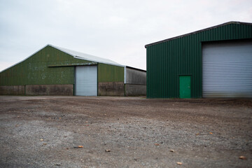 Fototapeta na wymiar Farm barns and farm yard corrugated green countryside view