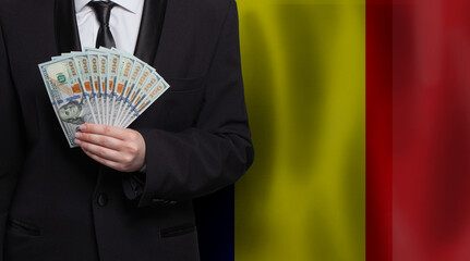 Male model showing 100 US dollar bills money banknotes against Romanian flag background