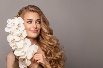 Naklejka premium Attractive young woman with beauty long curly hair. Fashion model portrait on white background