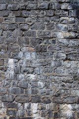 The texture of the stone wall in gray. Rough grunge texture of natural origin.