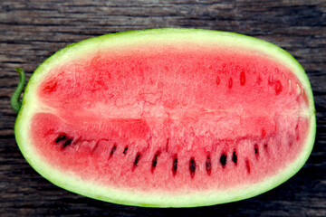 Fototapeta na wymiar Juicy fresh red watermelon on the table. Watermelon sliced into pieces on a wooden texture background. The concept of food, happiness, sweets and desserts.