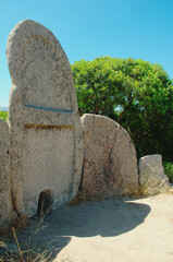 Arched stele and part of the exedra of the Giants' grave of S'Ena'e Thomes ( nuragic-era archaeological site), Sardinia, Italy - obrazy, fototapety, plakaty