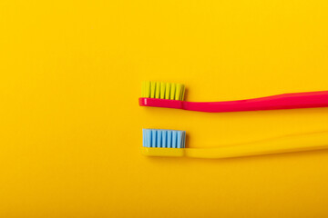 Oral care. Toothbrushes on a yellow background. The concept of cosmetic products for the bathroom. Flat lay, copy space. A set of oral care products. Oral hygiene