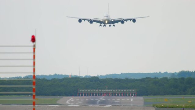 Widebody four engine double deck aircraft approaching landing. Cinematic footage of a huge unrecognizable airliner flying. Airplane silhouette arriving at the airport