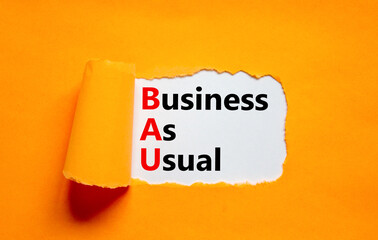 BAU business as usual symbol. Concept words BAU business as usual on white paper on a beautiful orange background. Business and BAU business as usual concept. Copy space.
