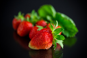 Ripe juicy red strawberry on black background