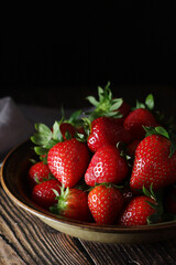 A bowl with ripe bright strawberry in rustic style