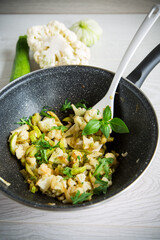 cauliflower fried with zucchini and vegetables in a pan