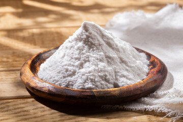 Baking soda in wooden bowl on the table