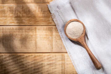 Green plantain flour, in wooden bowl, top view