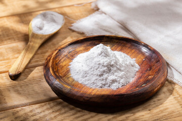 Baking soda in wooden bowl on the table