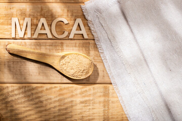 Maca powder, in wooden bowl on the table, nutritional substance from Peru