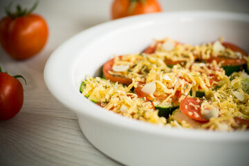 raw zucchini and tomatoes sliced with cheese, prepared for baking