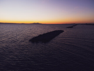 Silhouette of breakwaters on sea and on dusk time.