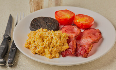 English styled cooked breakfast on a white plate on a white background.