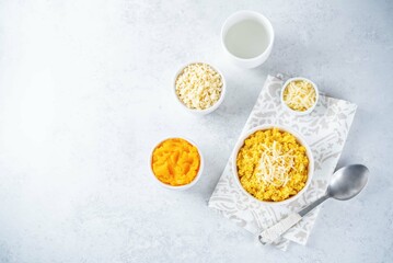 Millet porridge with pumpkin puree and cheese in a bowl