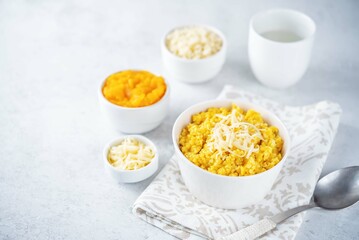 Millet porridge with pumpkin puree and cheese in a bowl