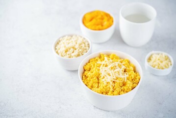 Millet porridge with pumpkin puree and cheese in a bowl