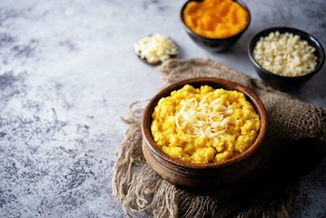 Millet porridge with pumpkin puree and cheese in a bowl