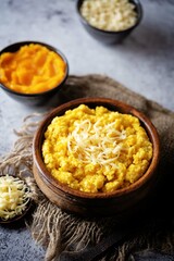 Millet porridge with pumpkin puree and cheese in a bowl