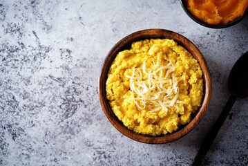 Millet porridge with pumpkin puree and cheese in a bowl