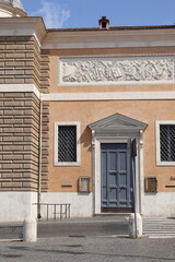 Santa Maria del Popolo Basilica Exterior Detail with Relief and Wooden Door in Rome, Italy