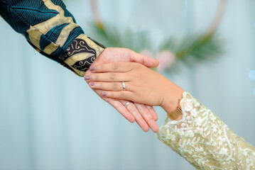Portrait of a pair of male and female hands with wedding rings. The day of the wedding ceremony. Hands of a newly married couple with wedding rings.