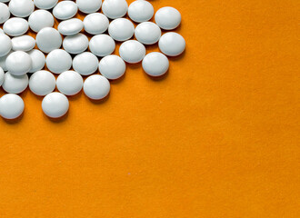 White medicinal pills on a colored background.