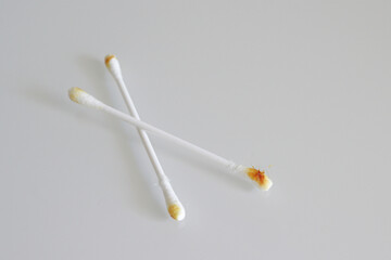 Cotton swab used for cleaning ear with sulfur on white background