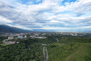 Fototapeta na wymiar Colombia - Ibague, vista de dron con una montaña, la ciudad de ibague, una carretera en la mitad y un maravilloso cielo.