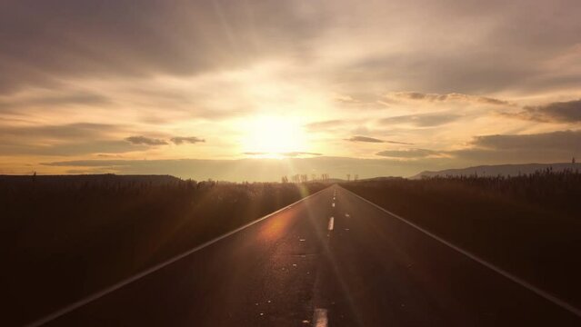 Driver POV - driving on the rural empty road at sunset in autumn
