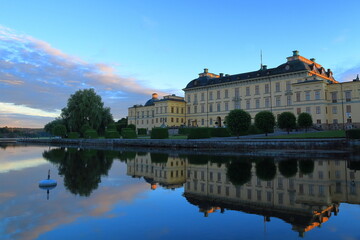 The Drottningholm palace. At sunset with reflection in the calm water. One old historic Swedish castle. Stockholm, Sweden.