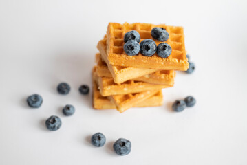 sweet dish Belgian waffles with blueberries on a white background