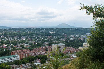 Fototapeta na wymiar Panoramic top view of the city of Pyatigorsk in Russia on a cloudy summer day and a copy space on the horizon