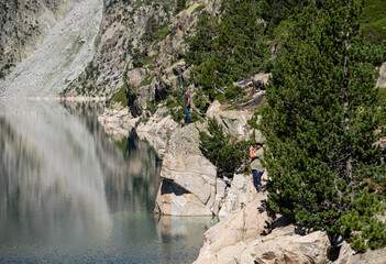 fishermen on a mountain rock hunting trout in a blue water reservoir
