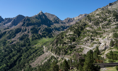 road and buildings below a mountain dam and reservoir
