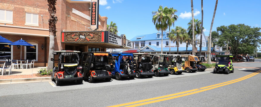 Golf carts parked side by side in downtown Sumter Landing, The Villages, Florida. The Villages is a popular retirement golf cart loving community.