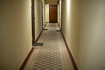 Corridor in house. Tiles in house. Doors in hallway. Entrances were flown.