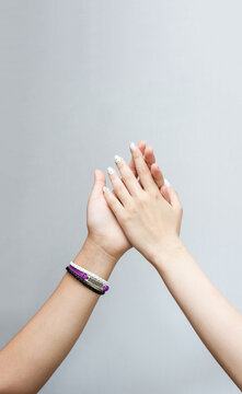 Young Women's Hands Greet Each Other And On One Of Them Is Best Friend Bracelet. Happy Friendship Day. Selective Focus, Copy Space