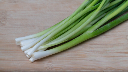 Green onion feathers lie on a wooden board close-up of greens