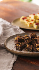Chocolate fudge on a rustic ceramic , wood surface and linen