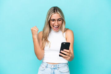 Fototapeta premium Young caucasian woman isolated on blue background surprised and sending a message