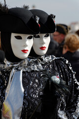 Fototapeta na wymiar Venise, Italie, 27 février 2014 : Carnaval de Venise, deux personnes avec le même costume noir et blanc, tels des jumeaux