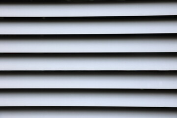 Gray blinds with black lines pattern on the window, jalousie closed straight