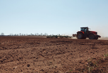 Fototapeta premium Tractor with seeder at agricultural field . Agricultural machinery at spring working