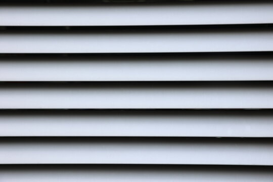 Gray blinds with black lines pattern on the window, jalousie closed straight