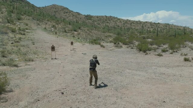 Person Shooting AR15 Pistol gun during Military Drill Training Aerial Drone 4k Footage outside in Arizona Desert on Sunny Day